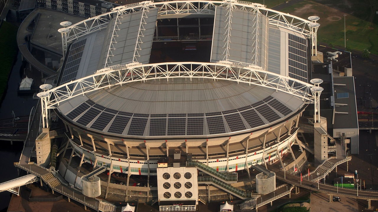 Johan Cruyff Arena in Amsterdam — Schräges Luftbild des runden Baus mit dem geschlossenen Dach