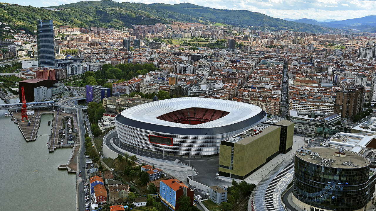San Mamés in Bilbao — Luftbild mit dem Stadion am Flussufer und der Stadt Bilbao dahinter