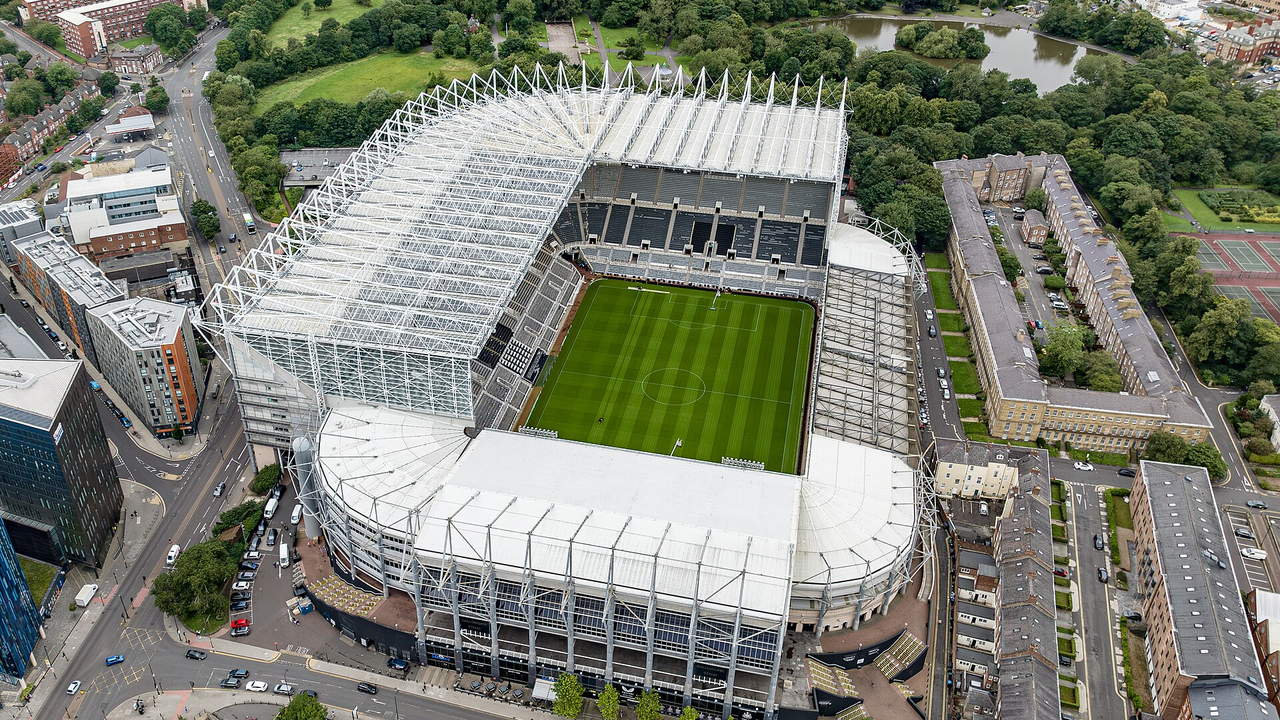 St James' Park in Newcastle — Luftbild mit den unterschiedlich hohen Tribünen, am Rand ein Park